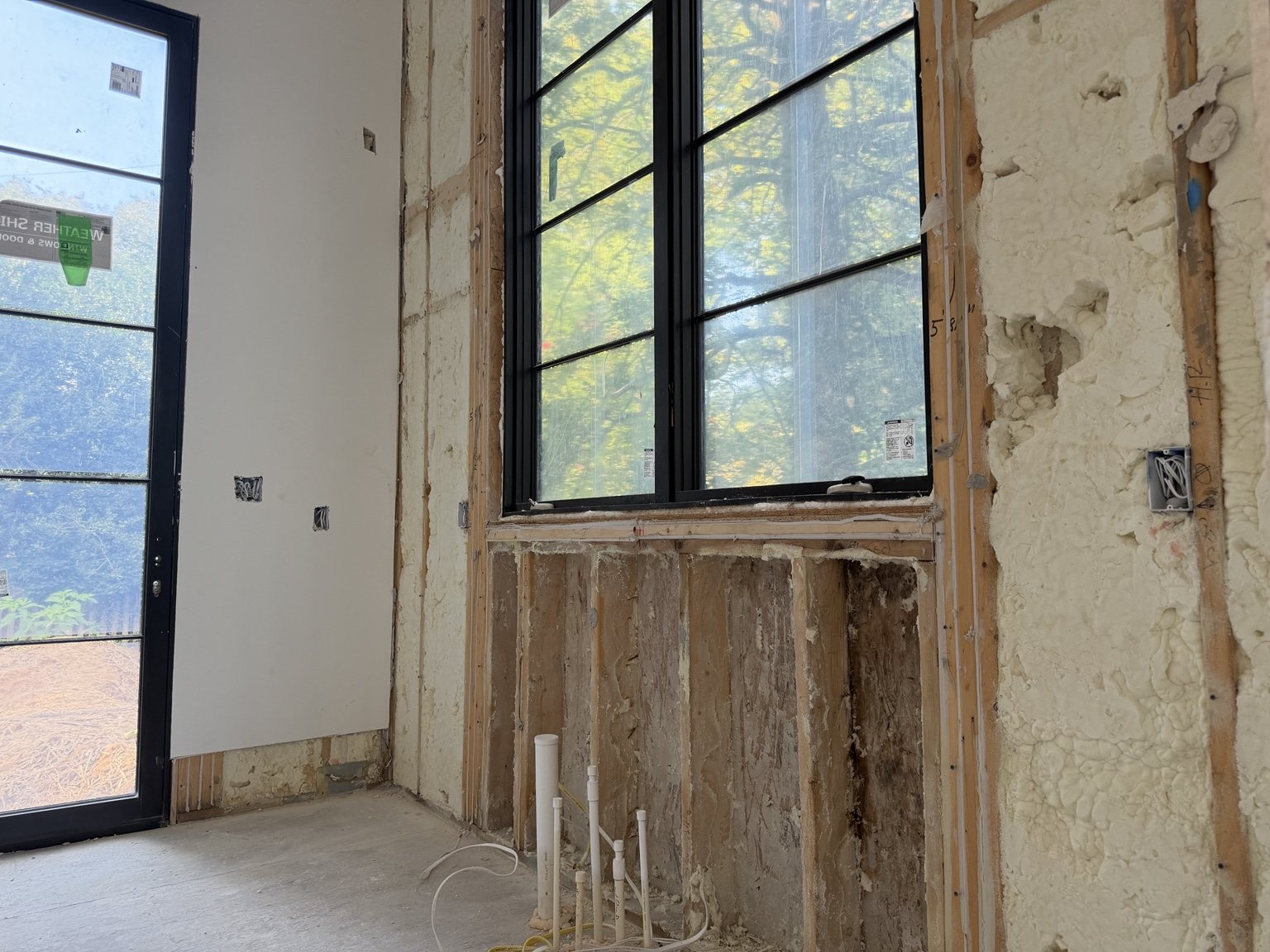 Open wall construction below a window showing exposed framing and concealed conditions